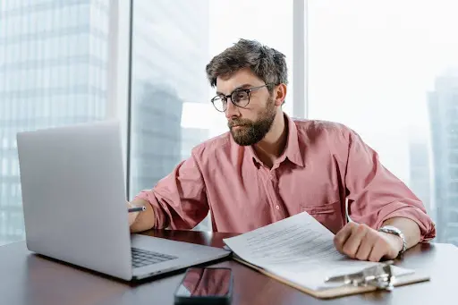 a man checking his bank statement on laptop