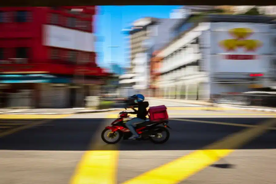 Motorcycle delivery rider transporting packages on the road